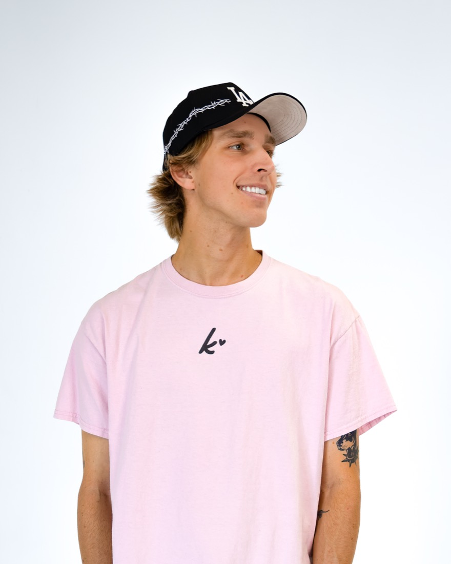 BBYFERG smiling in a pink tee and cap